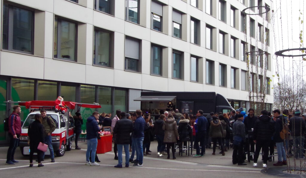 16 Glühweinmobil und Foodtruck, davor viele Gäste bei einer outdoor Weihnachtsfeier