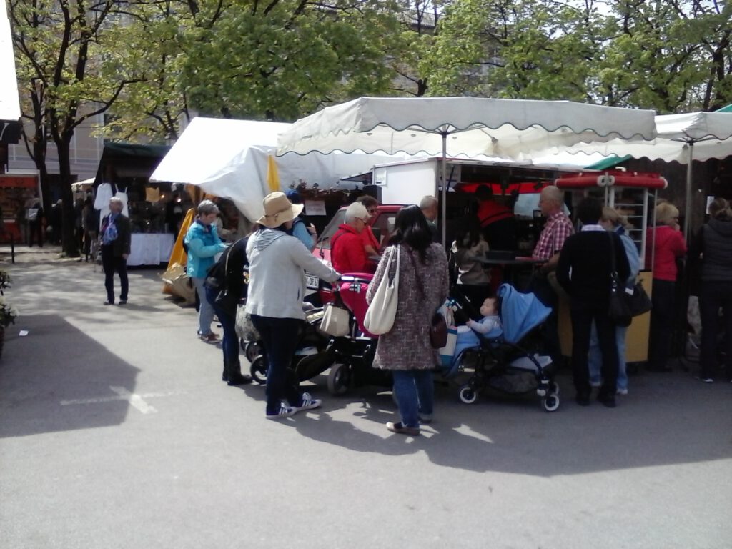 25 Kaffeedreirad auf der Auer Dult in München Gäste genießen Kaffeespezialitäten unter einem großen Marktschirm