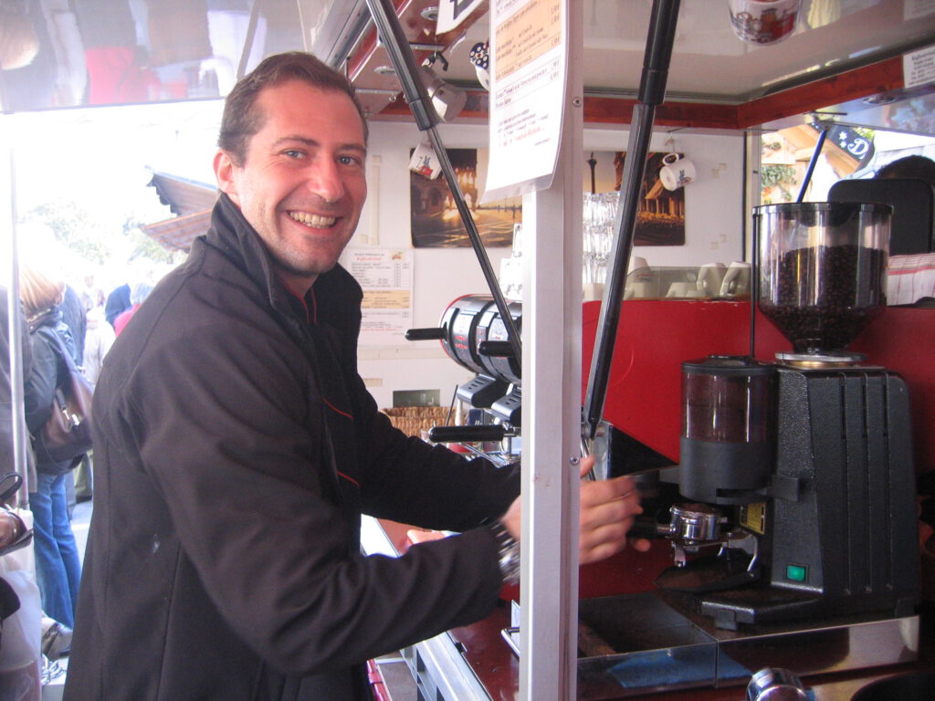 27 Barista bedient eine Espressomühle am Expressodreirad auf der Auerdult in München