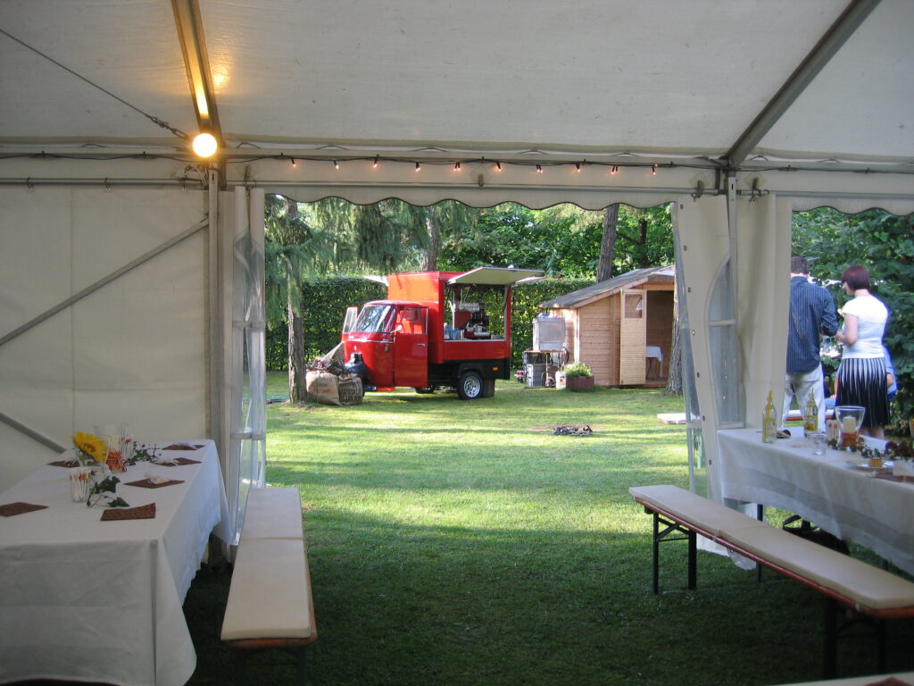 40 rotes Coffee Bike mit Spülmaschine steht vor einem weißen Zelt für eine Feier