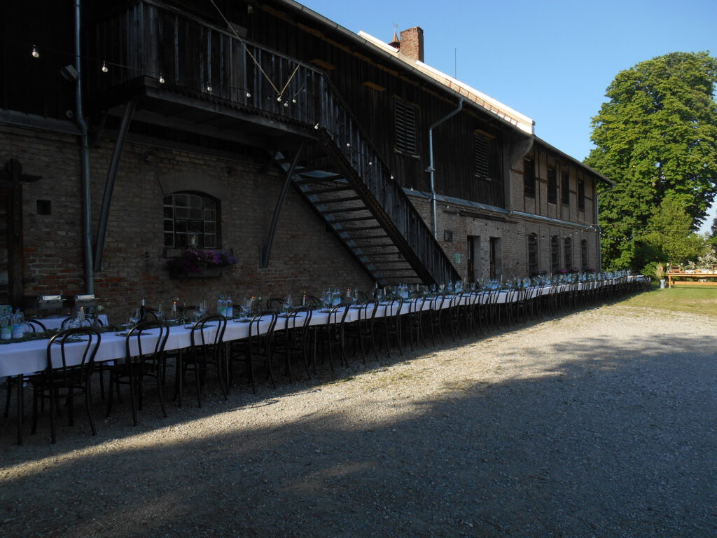42 sehr lange Tafel für 100 Personen vor alter Scheune für Hochzeitsfeier