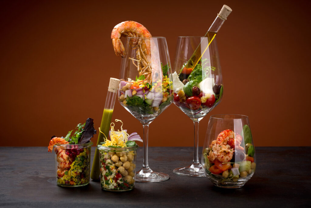 54 Stilgläser gefüllt mit Scampi und Salaten serviert für eine Jahresabschlussfeier